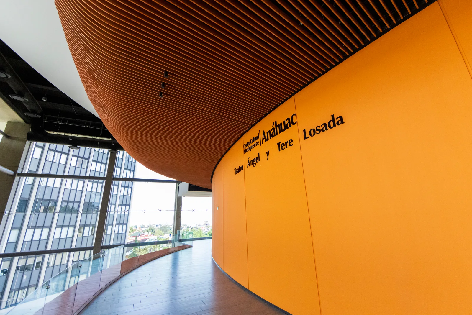 Interior del vestíbulo con elementos de madera curvada naranja