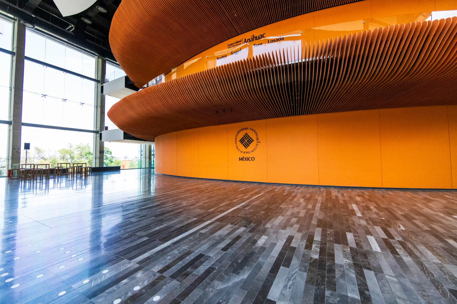 Vestíbulo acristalado y volumen curvo naranja del Centro Cultural Anáhuac